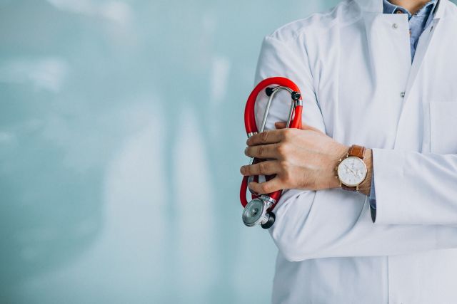 Young handsome physician in medical robe with stethoscope