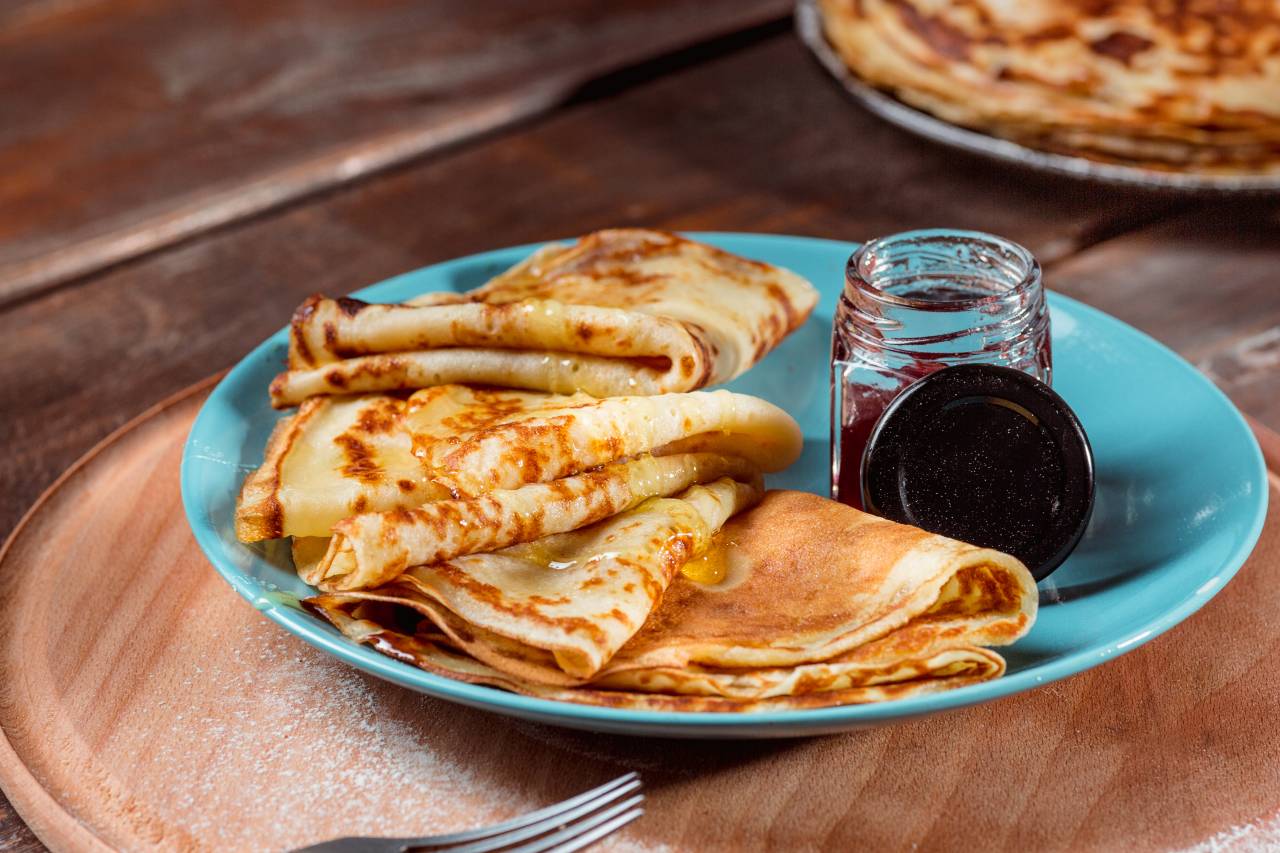 Fresh homemade french crepes made with eggs milk and flour filled with marmalade on vintage plate